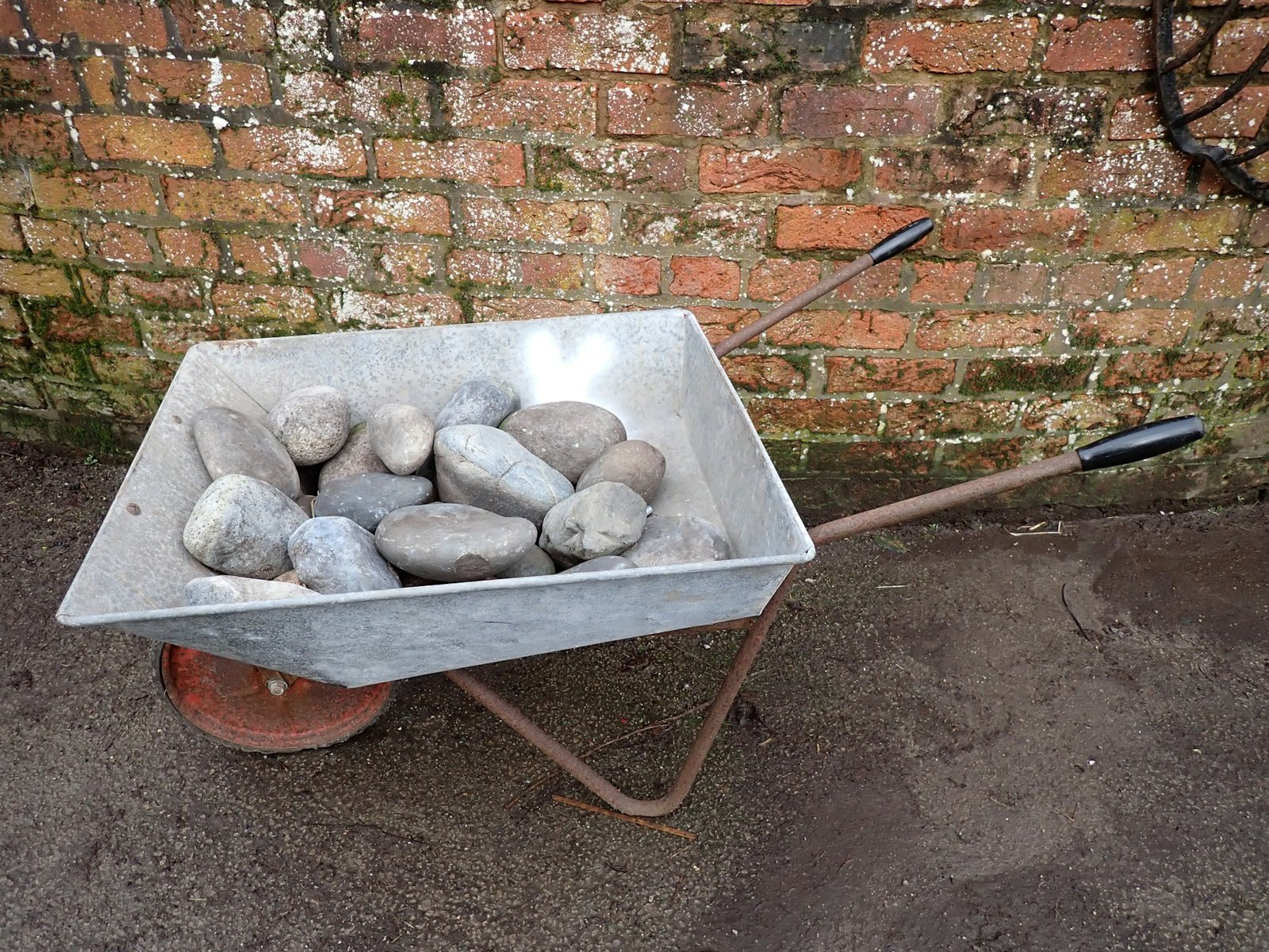 Wheelbarrow filled with landscape rock for a residential yard cleanup