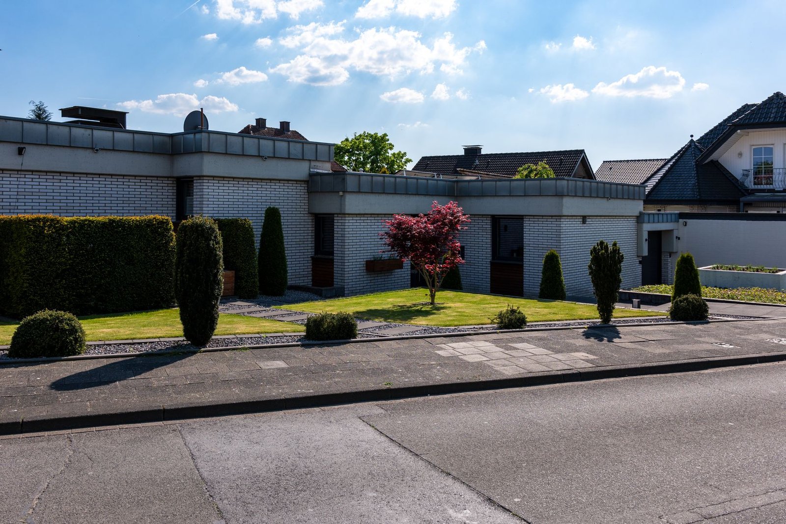 Residential home with a clean green lawn and landscaped entry
